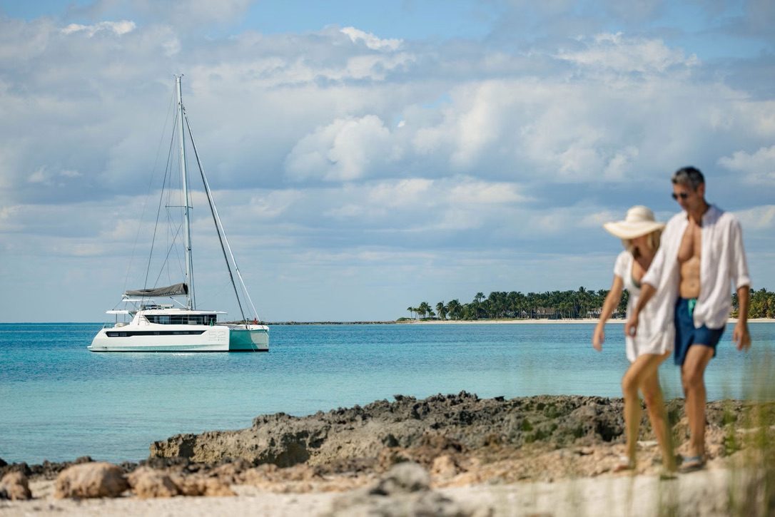 Couple on the beach with the boat anchored offshore